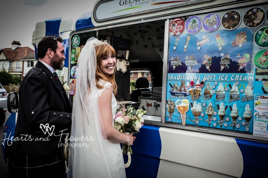 a bride and groom are buying ice creams from an ice cream van