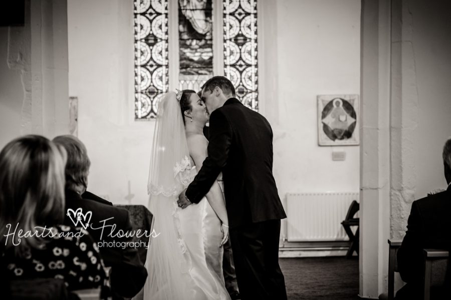 bride and groom having their kiss at the church altar
