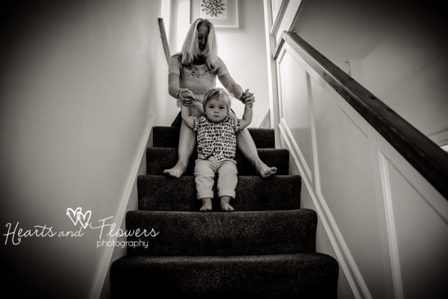 A mum helps her toddler come downstairs safely.