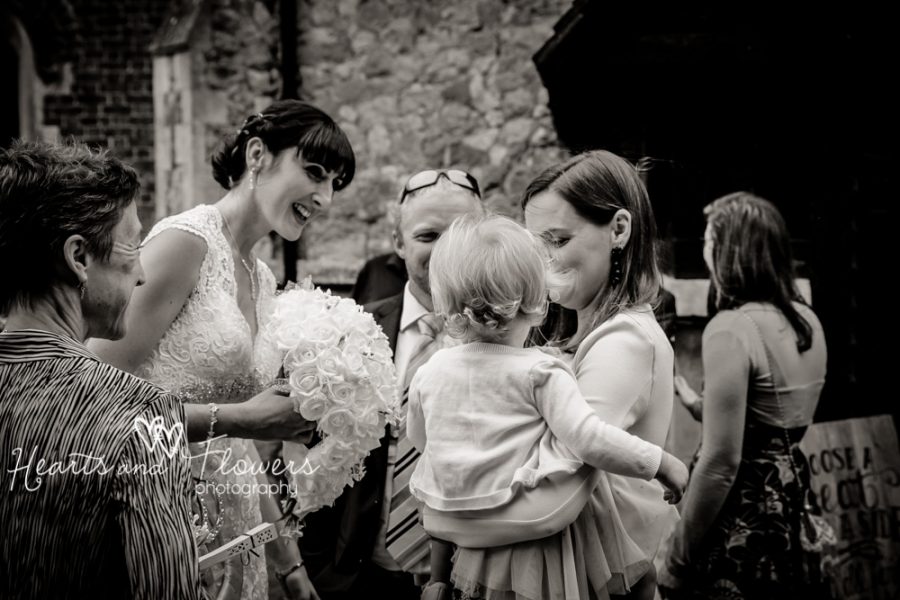 beautiful bride talking to a relatives baby after the wedding service