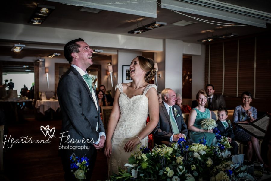 a bride and groom are throwing their heads back laughing during their vows