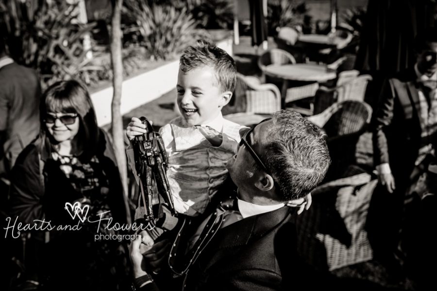 a little boy is being held up high by a relative at a wedding