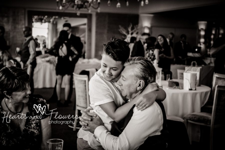 a little boy hugging his grandad during a wedding
