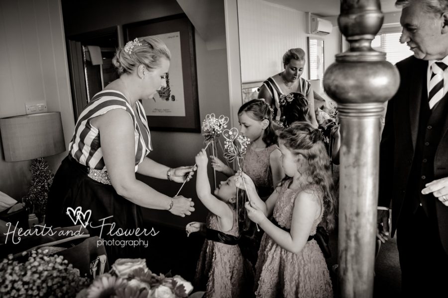 maid of honour is helping the flower girls get ready