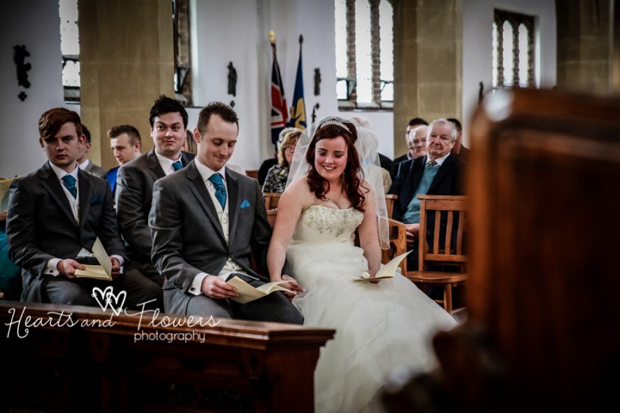 the bride is holding her grooms hand while the vicar says some words to them